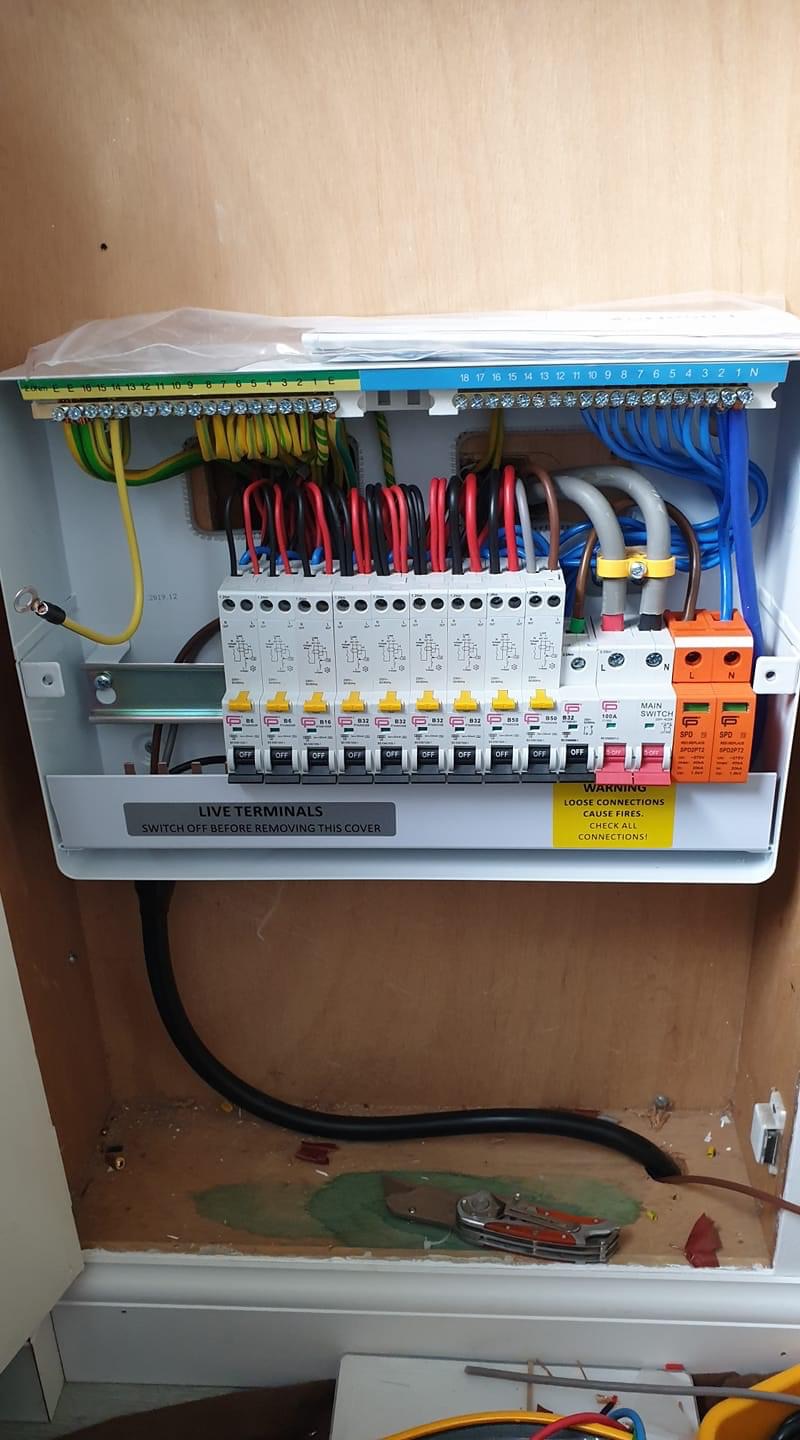 New consumer unit with neatly organised circuit breakers and colour-coded wiring