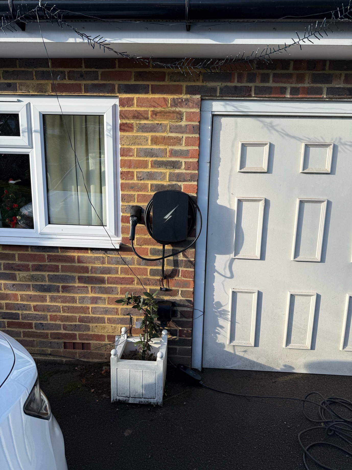 Electric vehicle charger mounted on exterior brick wall